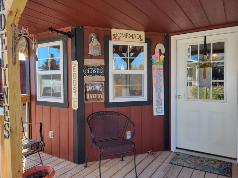 Deluxe Cabin close up view of a country store with red siding and metal roof.jpg
