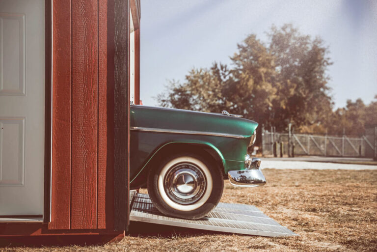 Garage red siding with antique car exiting