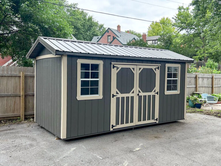 Garden Shed grey wood siding with metal roof and tan trim
