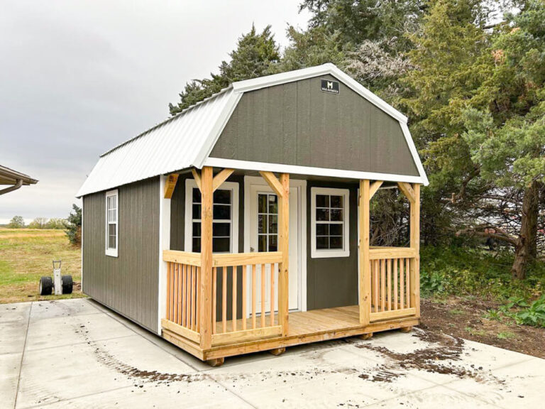 Lofted Cabin dark gray siding with white trim and metal roof with porch and wooden railing