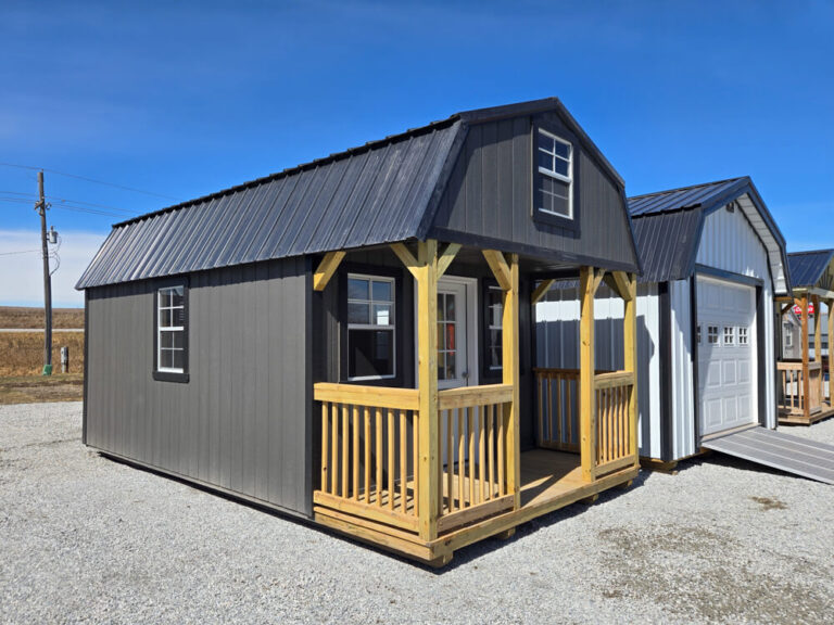 Lofted Cabin dark grey siding with dark trim and metal roof with porch and wooden railing