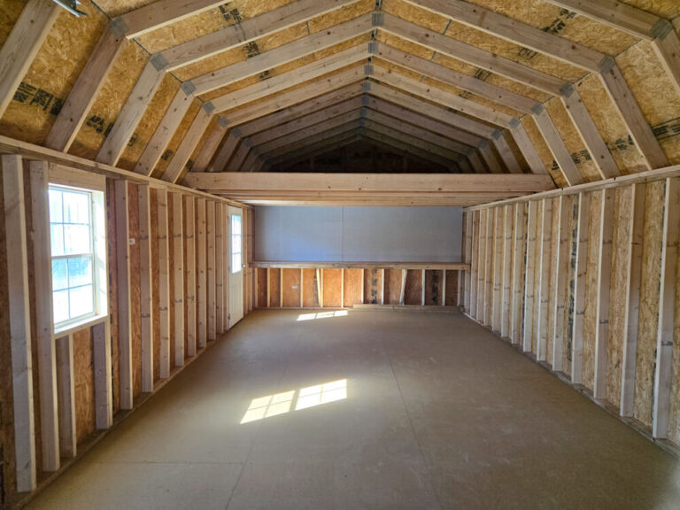 Lofted Garage interior view facing back with workbench and pegboard
