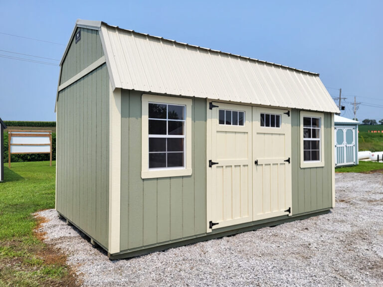 Lofted Garden Shed light green siding with tan trim and metal roof