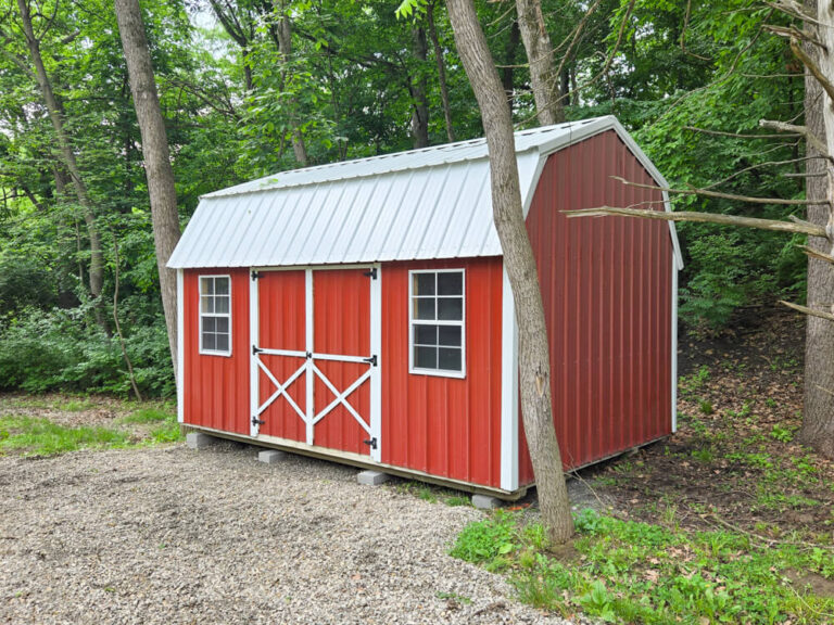 Lofted Garden Shed red siding with white trim and metal roof in forest
