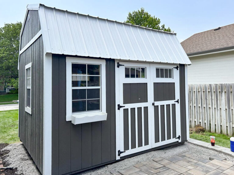 Lofted Garden Shed small dark gray siding with white trim and metal roof