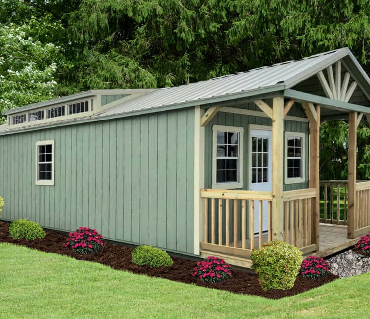 Green Swiss Cabin 12X32 with sage green paint, light stone trim and light stone metal roof