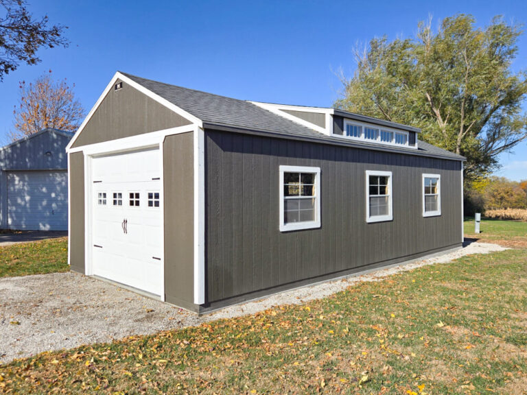 Legacy Garage with dark siding white trim metal roof with transom window on roof
