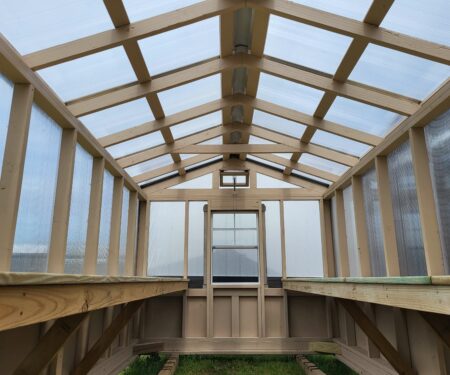 The inside of a greenhouse, with a window on the back wall, made by MidAmerica Structures