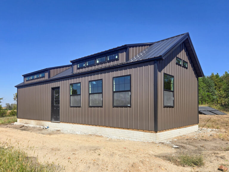 swiss cabin with dark siding black trim metal roof and transom windows in roof Shed Gallery